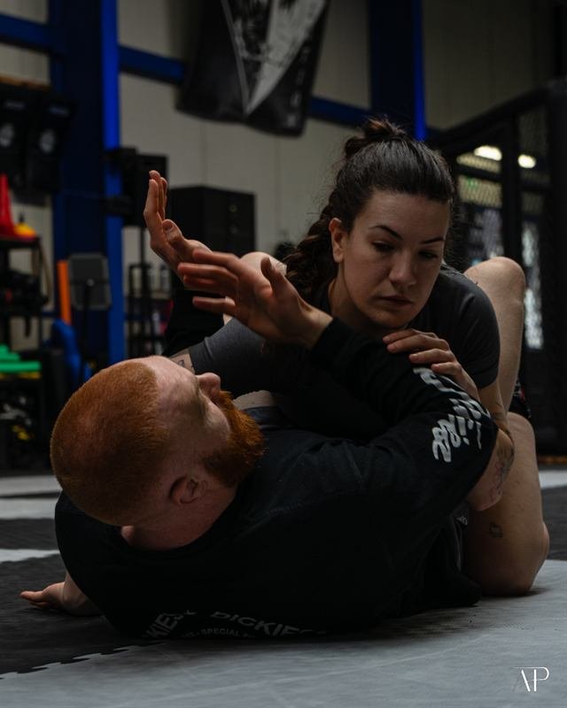 Trainerin und Trainingspartner beim Grappling-Techniktraining im Studio