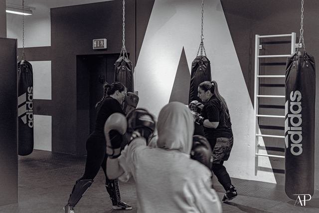 Kickbox-Training an mehreren Sandsäcken im Gym